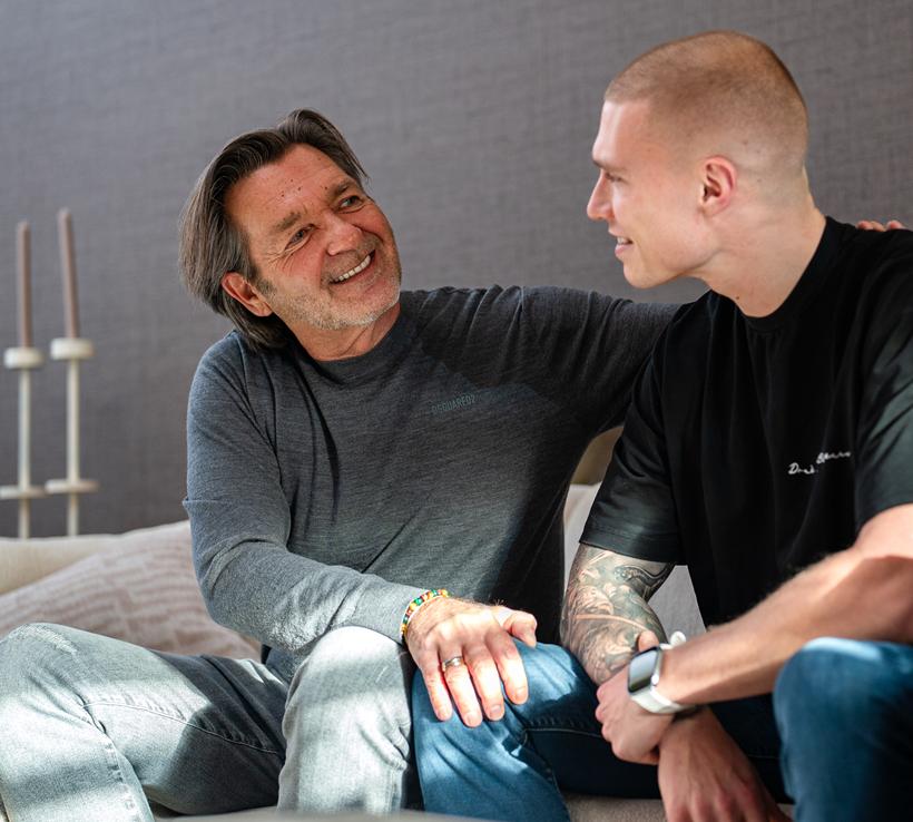 Vader met zijn arm om zijn zoon, hoopvol